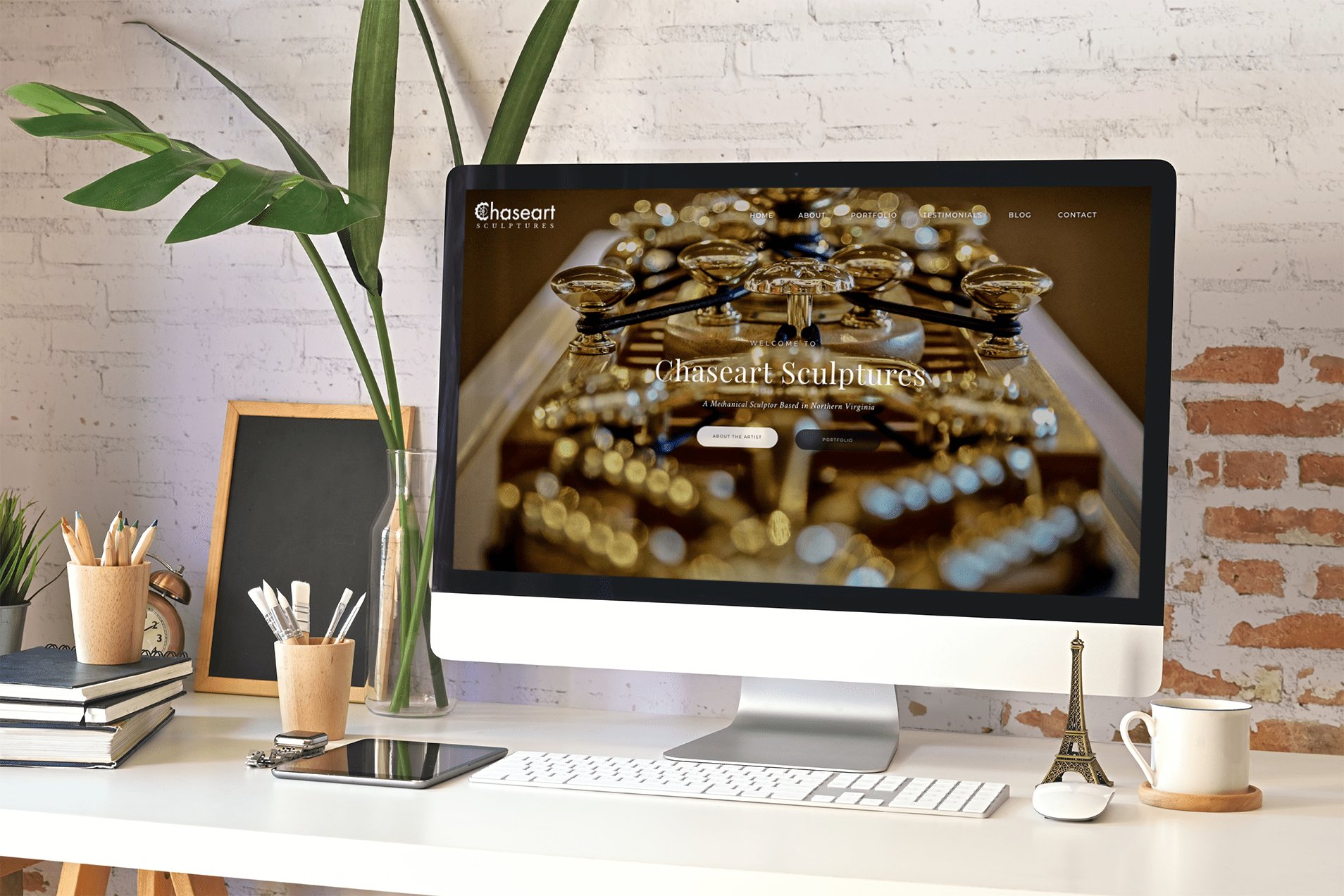 ChaseArt Sculptures homepage displayed on a desktop monitor, featuring a gold-toned mechanical sculpture